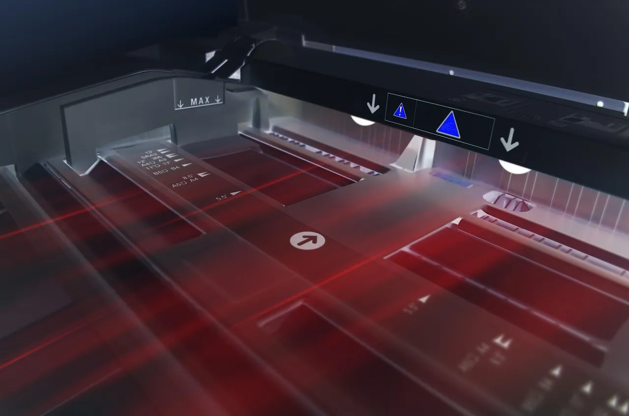 Close-up of a wide-format printer feeding paper through its rollers